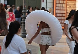 A tourist walks through Malaga city centre, heading towards the beach.