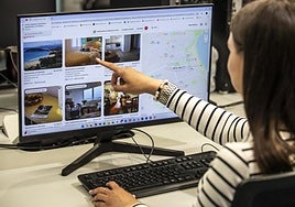 A young woman looks at advertisements for holiday flats.