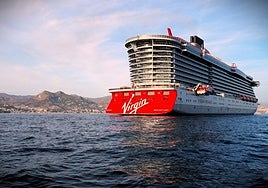 The Virgin cruise ship, anchored in the bay with the city in the background.