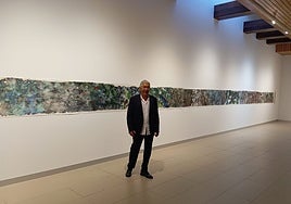 The artist poses with his 18-metre painting.