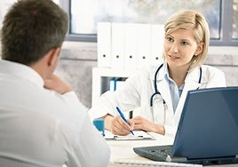 A doctor sees a patient in her consulting room at a health centre.