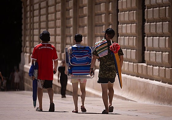 Tourists in the centre of the provincial capital head for the beach.