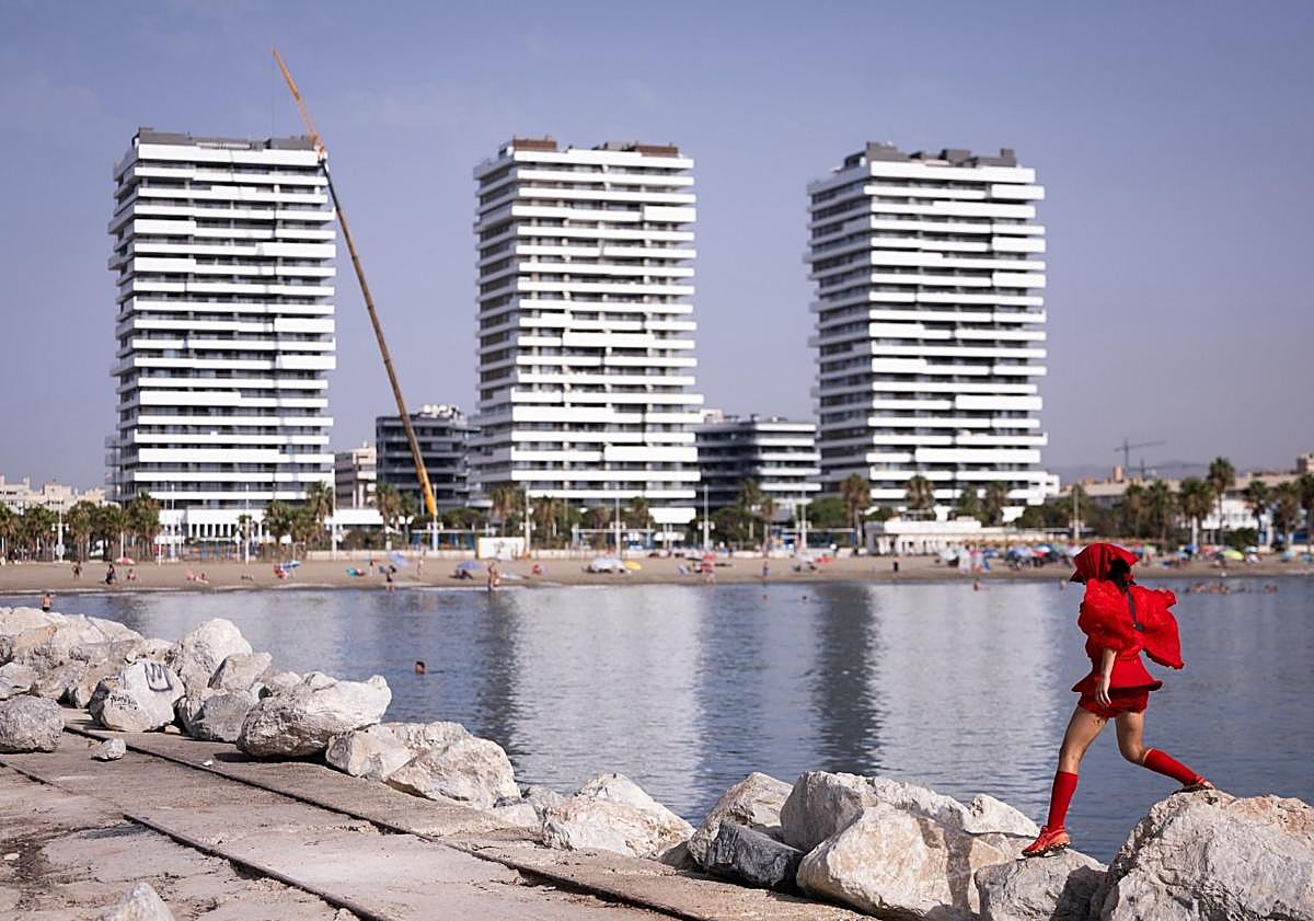 Imagen principal - Who is the woman in red crossing the beaches of Malaga?