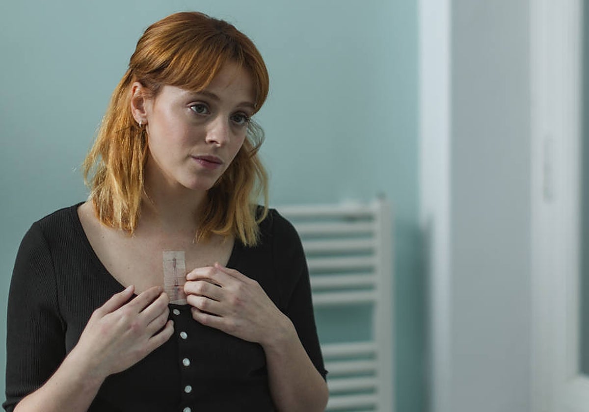 Cora Merlo, portrayed by Catalina Sopelana, shows the scar left after her heart transplant.