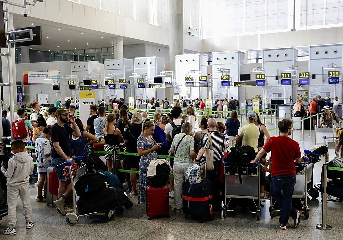 Passengers queue for the check-in desks at Malaga Airport.