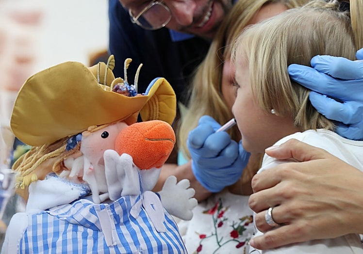 A doctor vaccinates a little girl.