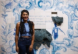Carla Hayes in front of a ceramic-tiled mural with woven raffia nets.