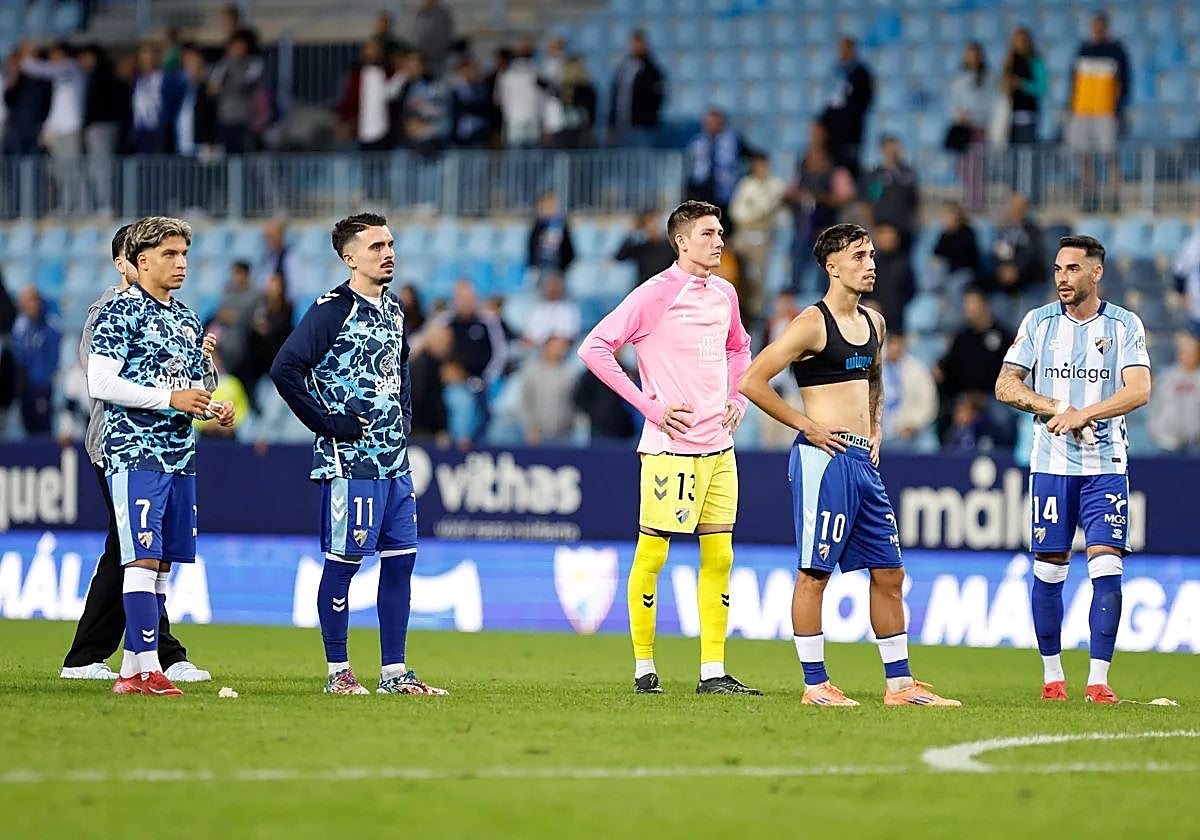 Malaga players at full time react to a chorus of boos.