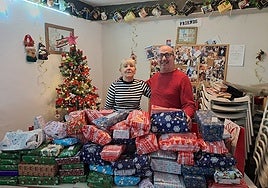 Carol Baxter and Claudio Castellon with gifts collected during last year's appeal.