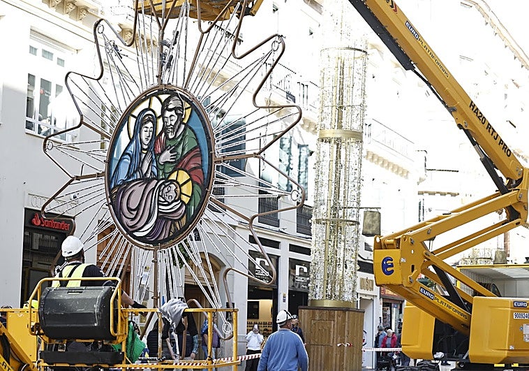 Workers hanging the first illuminated centrepieces on Calle Larios.