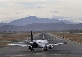 Plane preparing for take off and another in the air at Malaga Airport.
