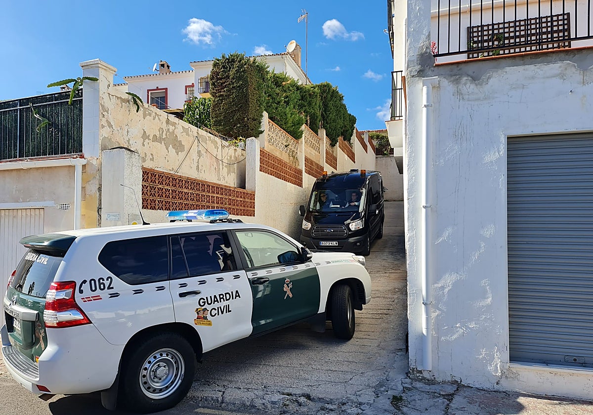 A Guardia Civil patrol and the funeral van, at one of the entrances to the urbanisation.
