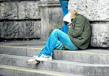 A homeless person takes shelter from the cold in the street.
