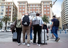A group of tourists with their luggage in Malaga city centre.