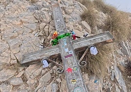 The vandalised metal cross lying among the rocks.