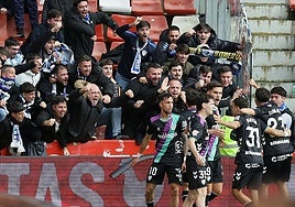 The Malaga players celebrate with the travelling fans on Sunday.