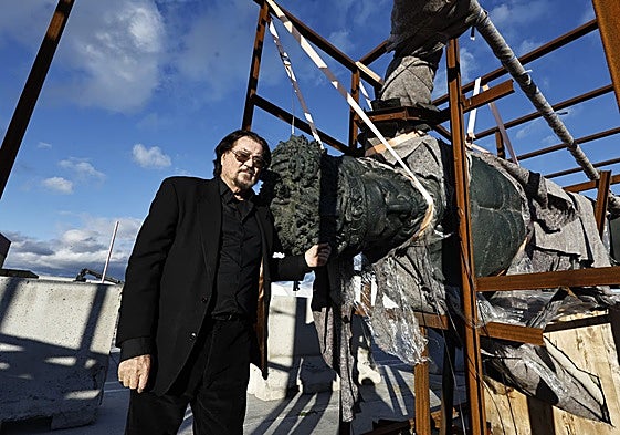Artist Ginés Serrán standing next to one of his works.