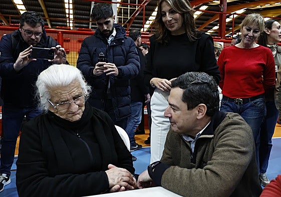 President of the regional government of Andalucía Juanma Moreno talking to an elderly evacuee at the sports centre in Ronda.