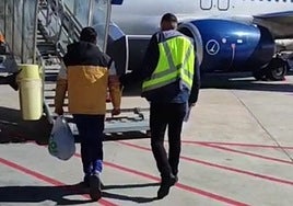 Photo of the detainee and a National Police officer walking towards the plane in Malaga.