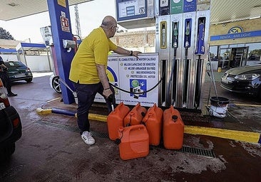 A customer filling up fuel bottles at a petrol station.