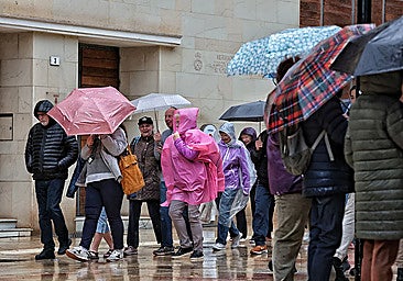 Archive photo of tourists walking around Malaga city centre under the rain.