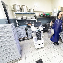 One of the professionals who tends the buffet at the Gran Hotel Luna gives Electra the dirty dishes.