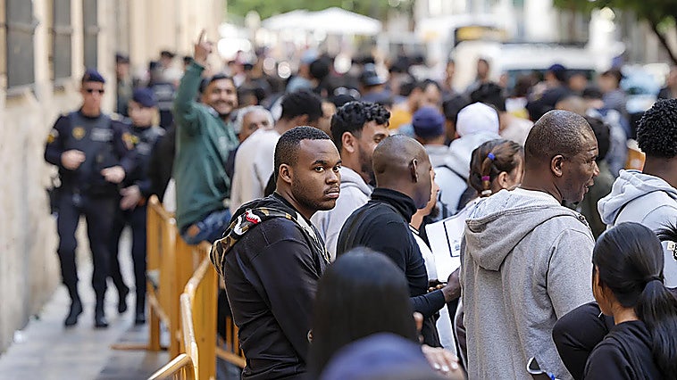 Photo of immigrants queueing to begin the regularisation process in Valencia.