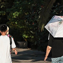 Tourists using umbrellas to protect themselves from the heat in Malaga.