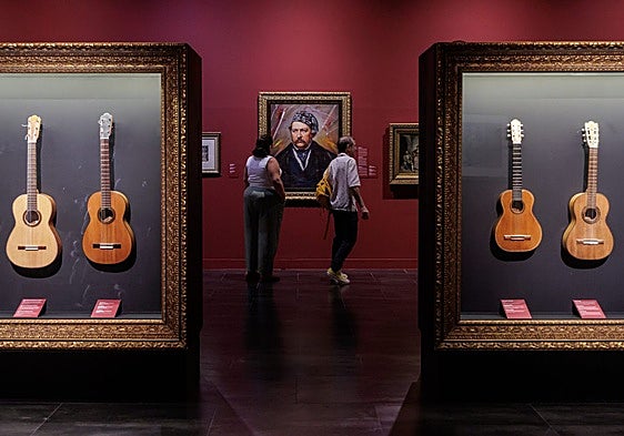 A collection of guitars with a portrait of Glinka in the background.