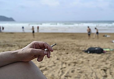 A holidaymaker smokes on a Spanish beach.