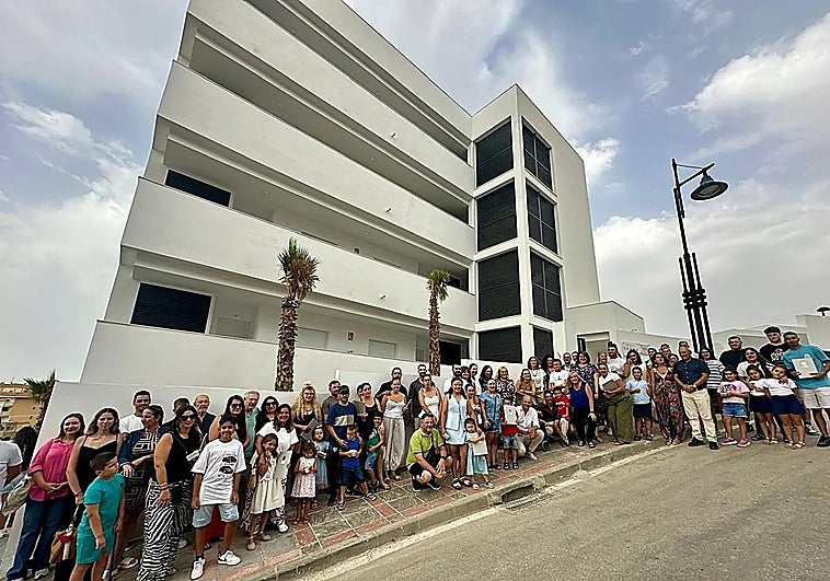 Photo of the families that have received the homes and the authorities responsible for their delivery in front of the building in Fuengirola.