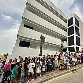 Photo of the families that have received the homes and the authorities responsible for their delivery in front of the building in Fuengirola.
