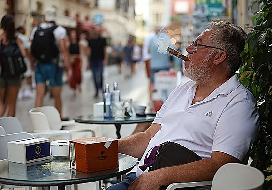 A man enjoying his cigar at a bar in Malaga.