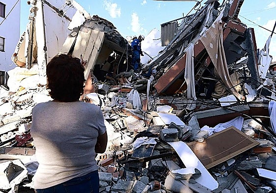 A woman watching as rescue teams search for survivors among the rubble of a building that collapsed following the earthquake in Pereira, Colombia.