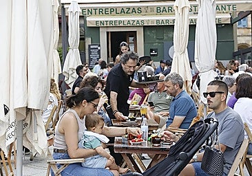 A waiter serving customers at a restaurant in Spain.