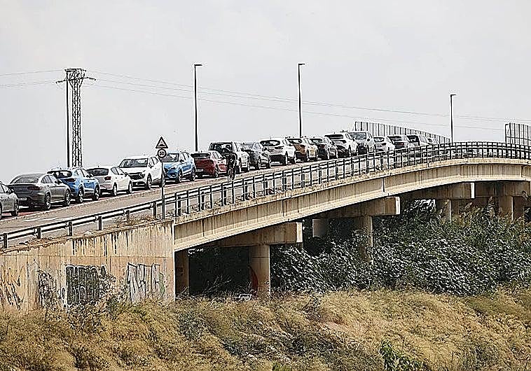 Imagen principal - Catarroja residents park their cars on the bridge in case of flooding. The ES-Alert on a mobile phone. Authorities activate contention measures.