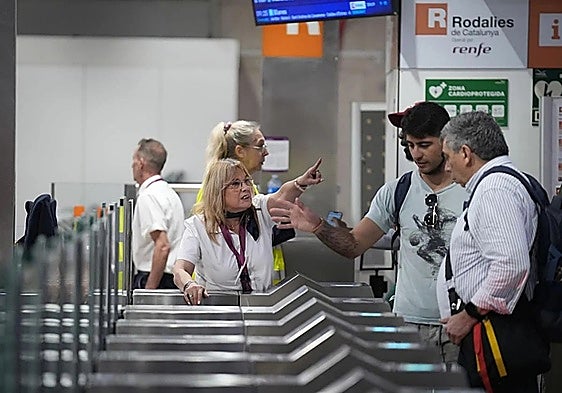 A Rodalies rail worker helping passengers at a station in Catalonia.
