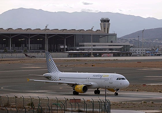 An aeroplane with the Malaga Airport terminal in the background.