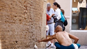 A man sitting on the ground on Calle Francisco de Rioja in Malaga.
