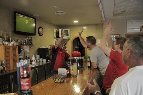 A customer celebrates Nacho's goal with Pepe Hierro.