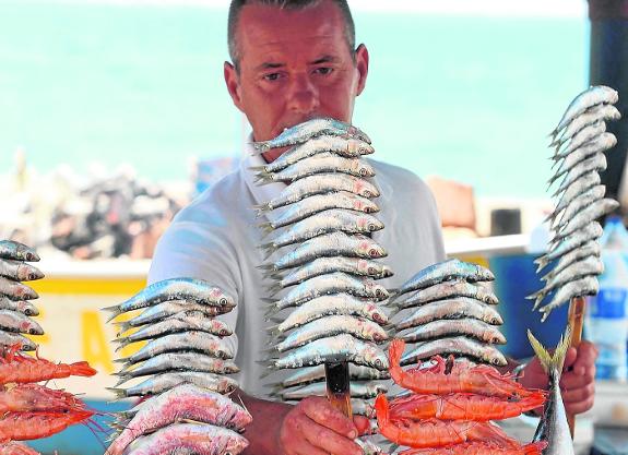 An 'espetero' prepares the canes of sardines on El Dedo beach in El Palo.