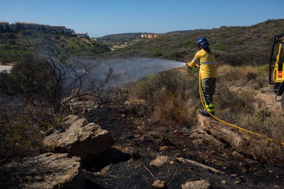 A firefighter damps down the fire near Manilva on Monday.