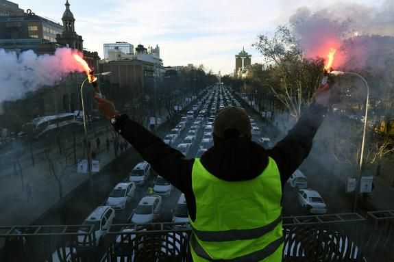 A striking taxi driver hails the blockade of Madrid's Paseo de la Castellana avenue earlier this week.