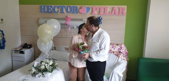 A kiss for the bride and groom after the wedding in a bedroom at the Quirónsalud Malaga hospital. 