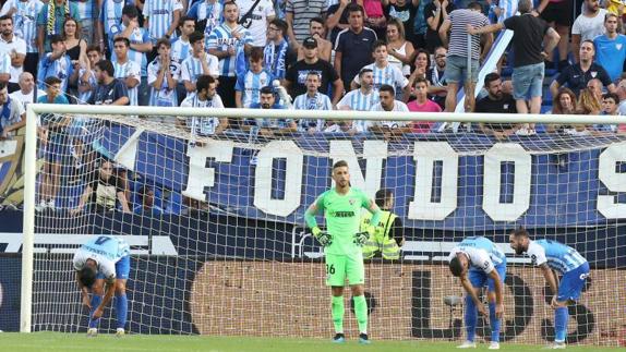 Malaga's defence looks despondent after going behind against Cadiz.