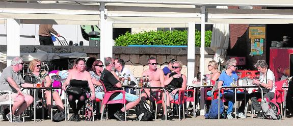 Tourists in December at a bar on La Malagueta beach in Malaga.