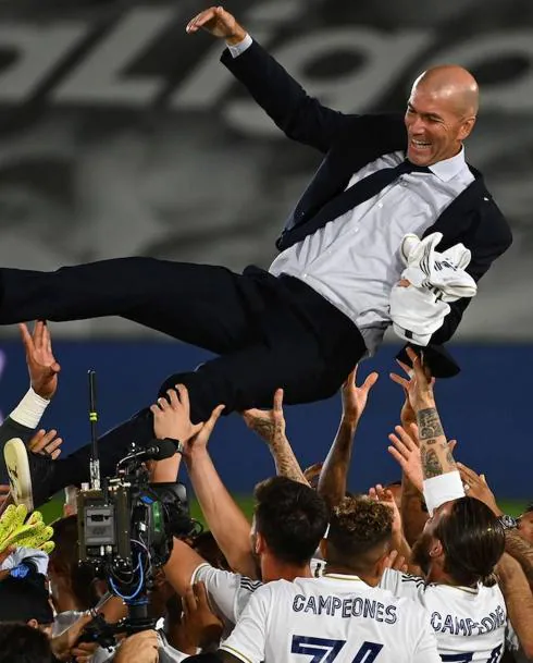 Real Madrid players toss Zidane to celebrate their Spanish league title.