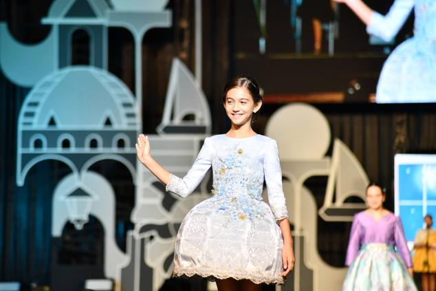 Una de las candidatas infantiles saluda a los foguerers y barraquers durante el desfile individual.