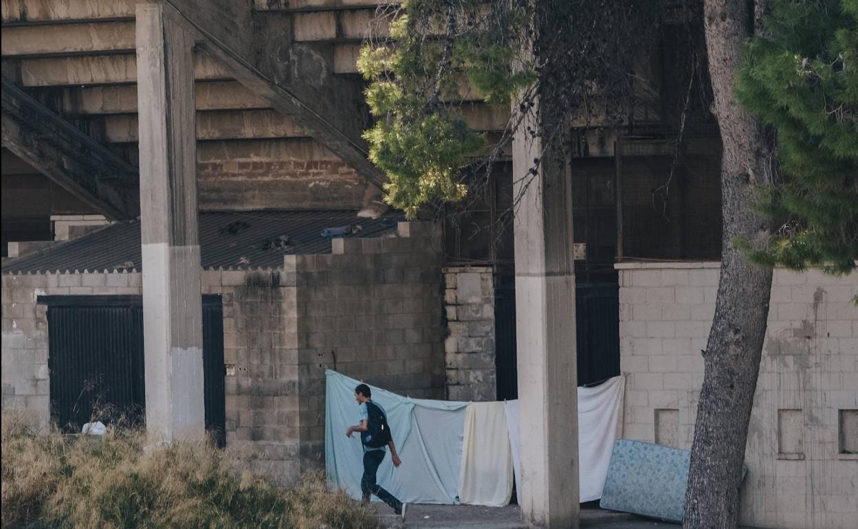 Un transeúnte paseando por los aledaños del Rico Pérez ante sábanas y un colchón 