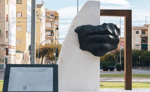 Monumento en homenaje a los fallecidos, una boca sobre un bloque de mármol y un arco de bronce. 